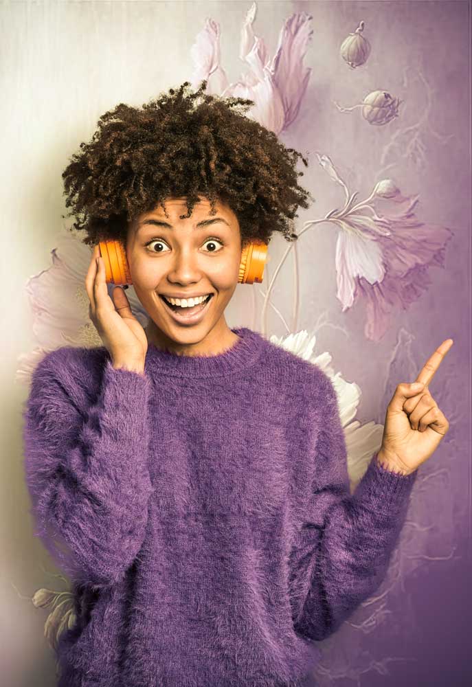 laechelnde afro-amerikanerin mit violettem pullover und kopfhoerer