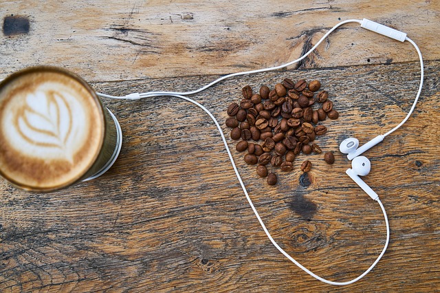Frischer Kaffee und Bohnen umrandet von Kopfhörer