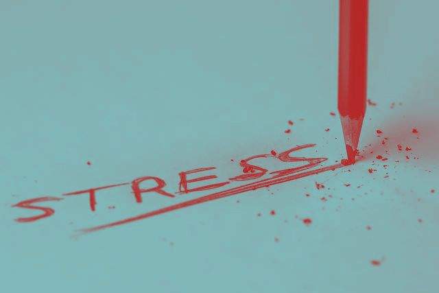Das Wort Stress wird mit rotem Bleistift geschrieben